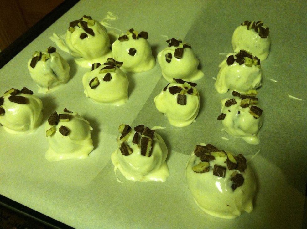 Using a fork to hold the balls, pour the melted chocolate over each individual dough ball with a spoon and let it drip off the fork before rolling onto the baking sheet. Sprinkle with chopped mints.