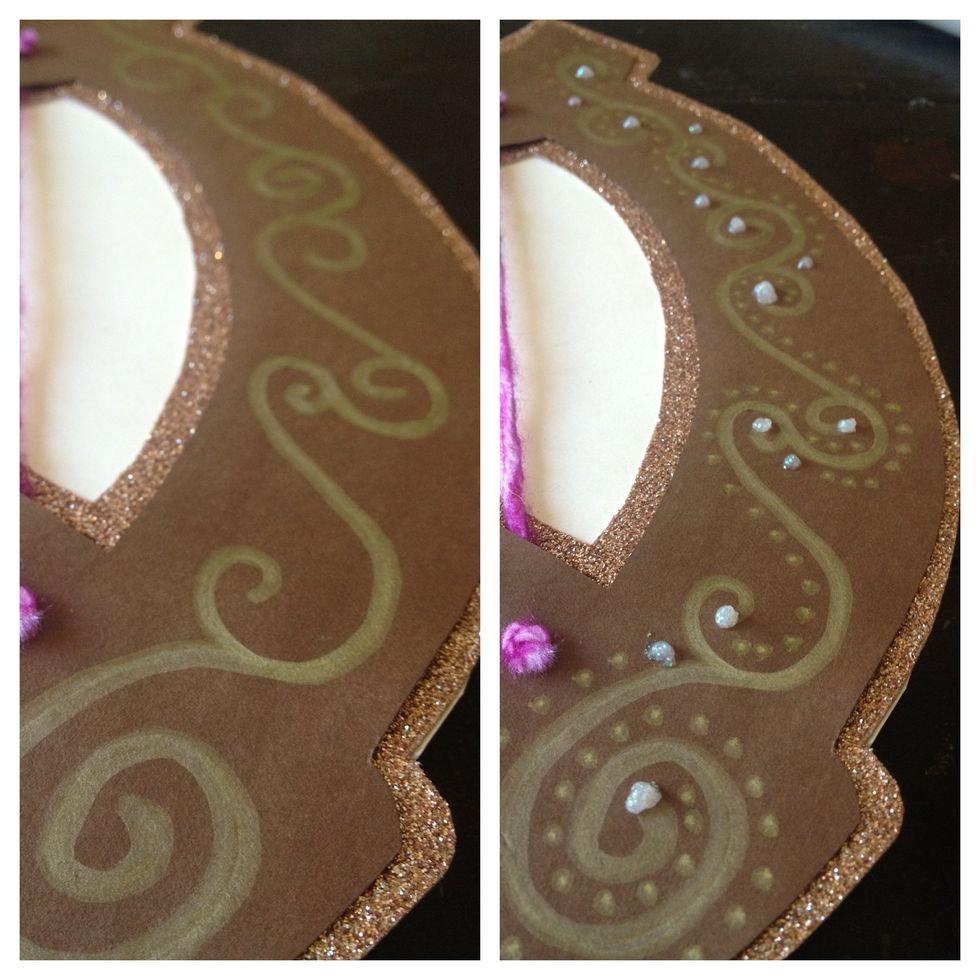 using a gold paint pen and glitter glue I added detail to the front of the card...