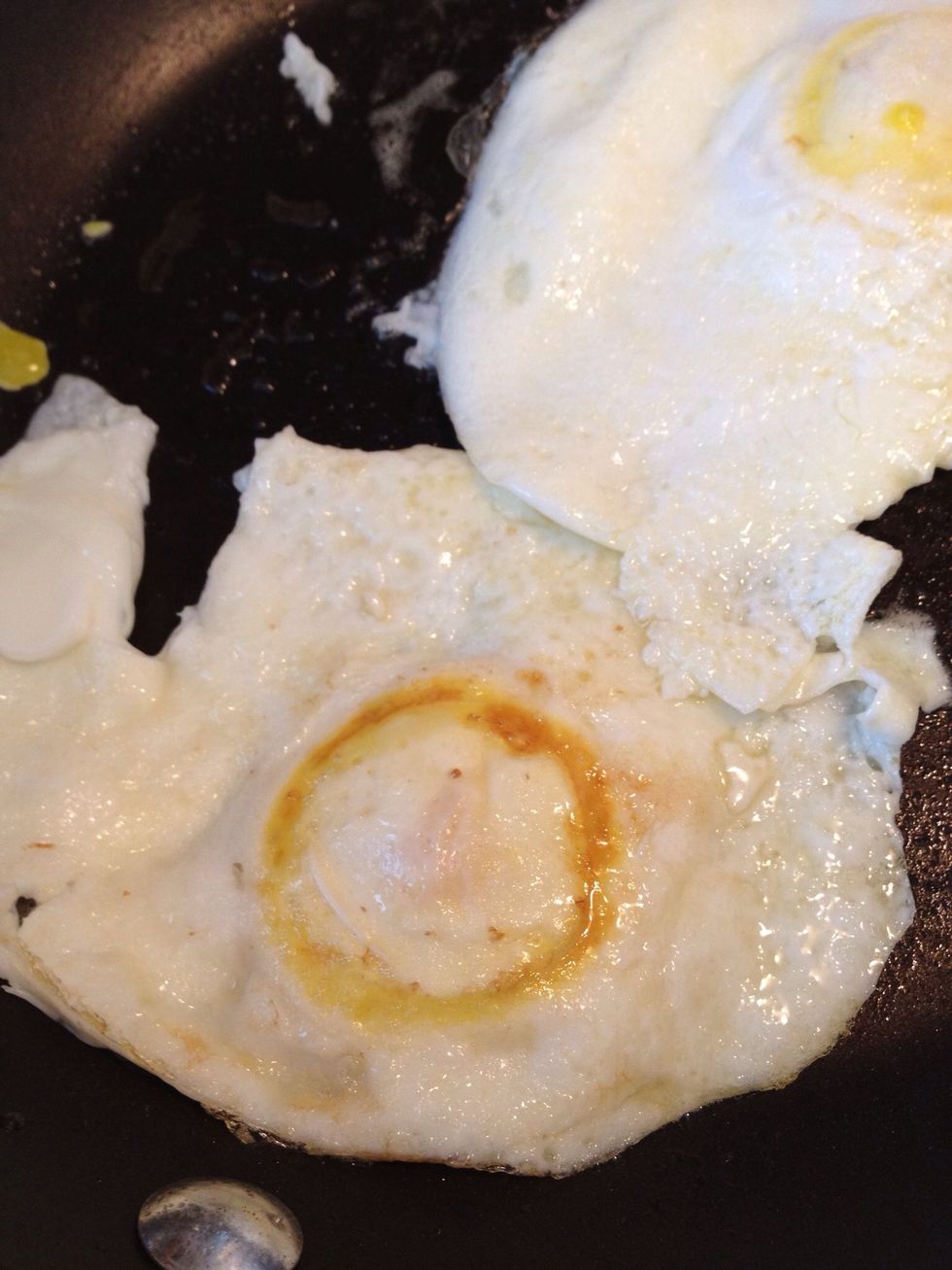 Using a good, stiff spatula, get under the egg at the yolk and gently flip it. This egg is now upside down in the pan.