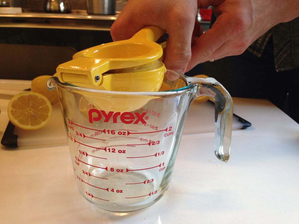Using a hand held lemon squeezer, squeeze lemon halves into a measuring cup ensuring there is 1 oz for each drink. Set juice aside.