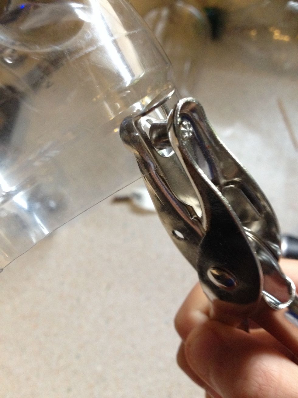 Using a hole puncher, punch two holes in the front and two in the back of your top half, then do the same to the bottom half