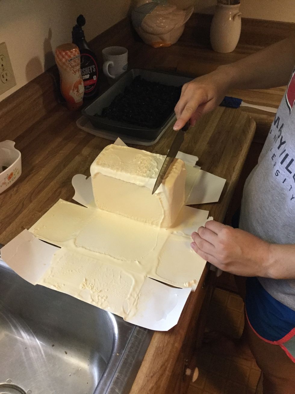 Using a knife, cut cardboard off vanilla ice cream and cut 1/2 gallon of ice cream into slices.