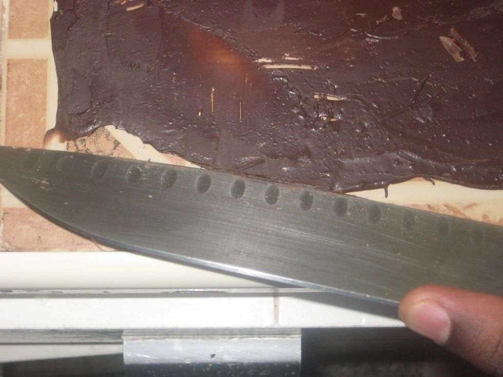Using a knife scrape off the chocolate by placing the knife at the angle above