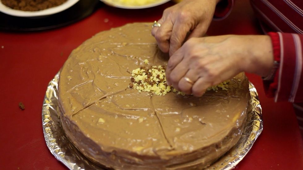 Using a knife to guide your decoration as you like. Ours is a radioactive flower lol. Coz that's just what it looks like. This cake will need a hazard sign.