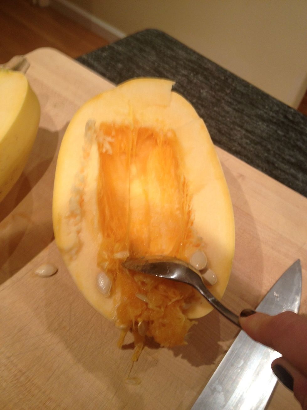 Using a large spoon, scrape out the seeds.