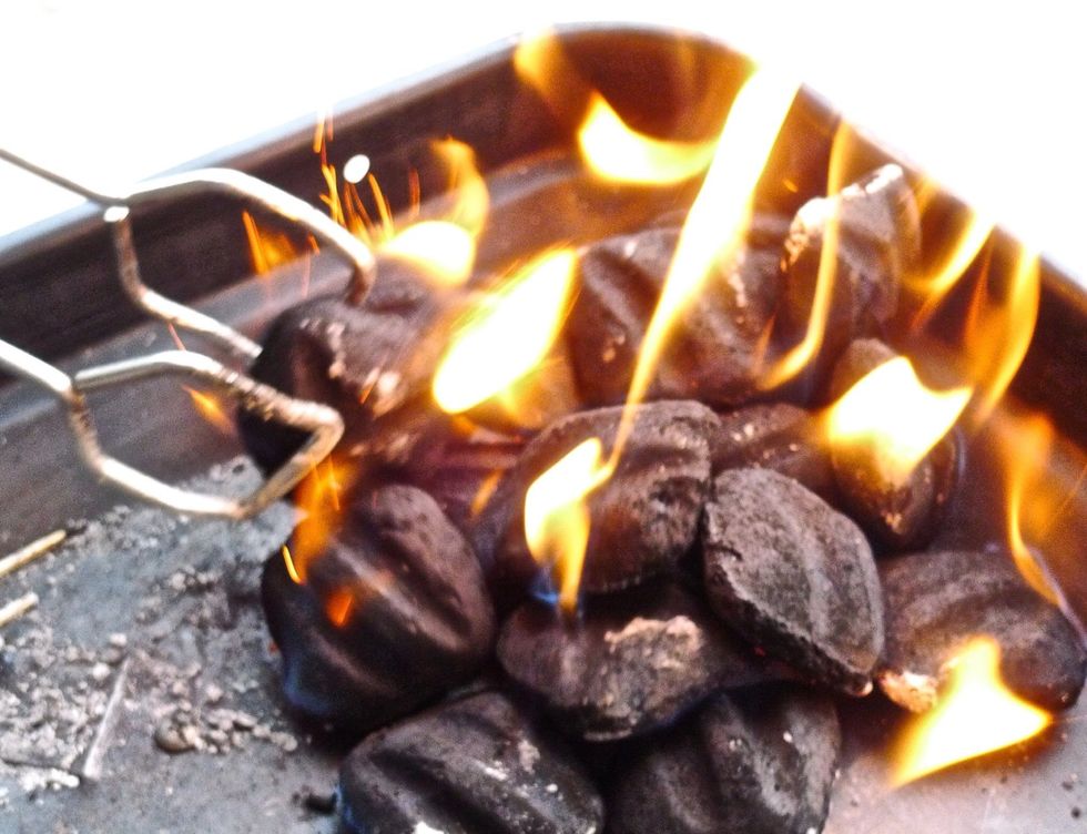 Using a long match, light the charcoal briquettes in the grill. It will take about 15 minutes for the charcoal briquettes to be hot enough for the grill. Use a grilling tong to even out the flame.