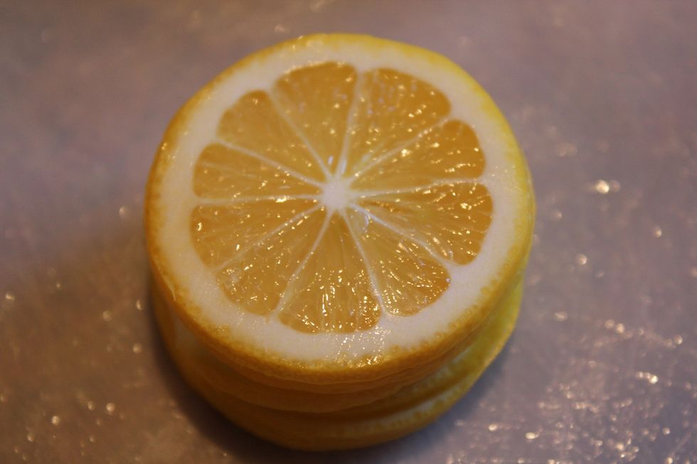 Using a mandolin or sharp knife, slice the lemons crosswise into thin rounds, discarding the seeds as you go.