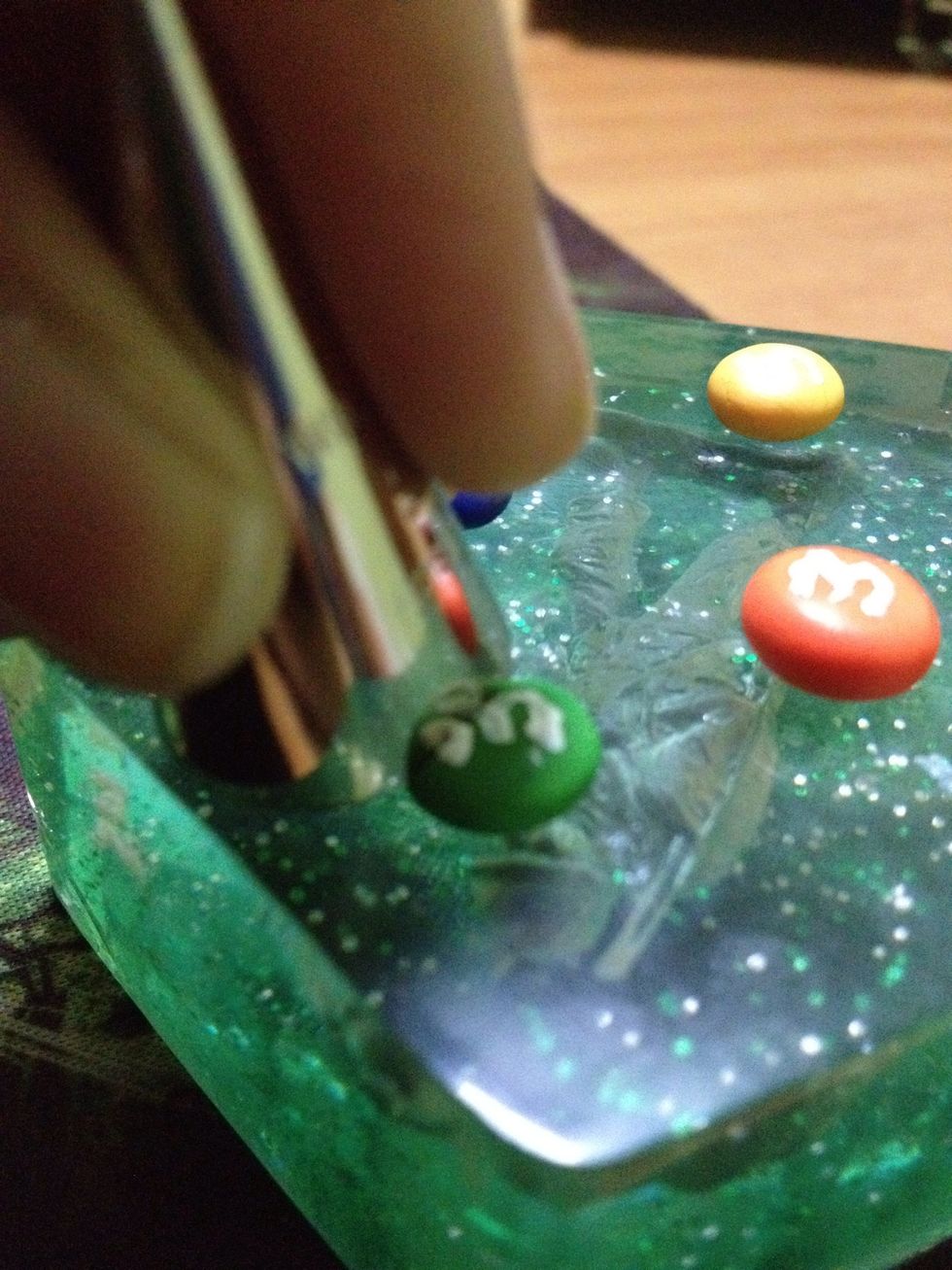 Using a Milton cone or practically anything, cut out a 'bite' from the M&M.