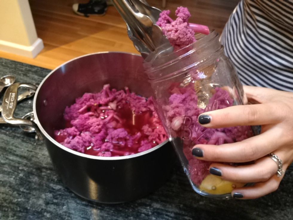 Using a pair of tongs, place the cauliflower into the quart jar.