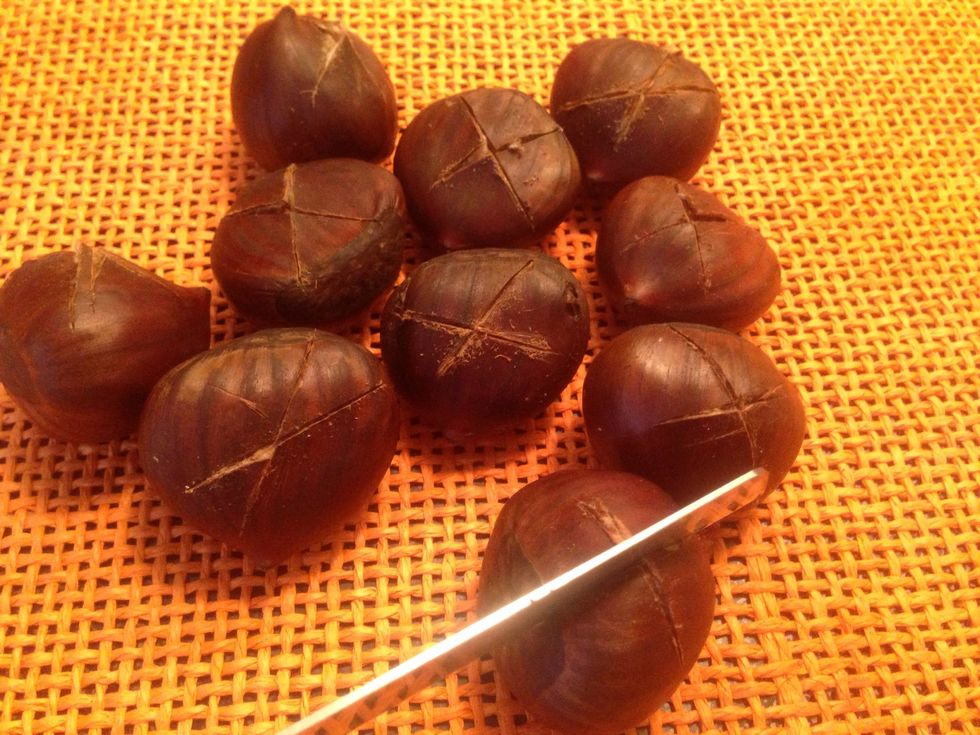 Using a pairing or sharp knife cut an "X" on the flat side or a slit all the way around each chestnut. Cut through the shell of the chestnuts so that they can expand and cook faster.