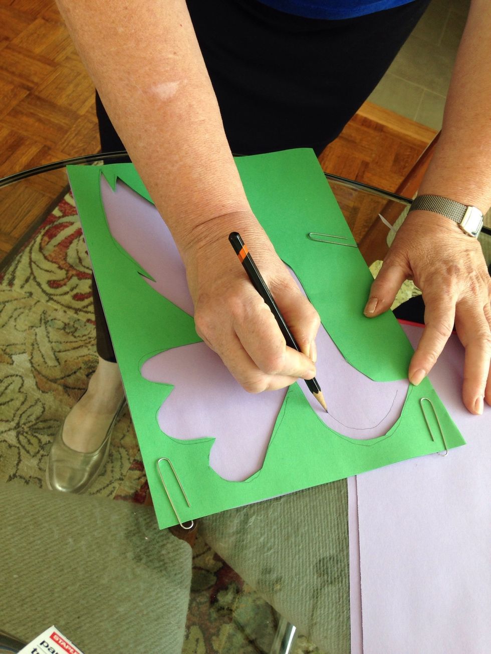 Using a paper clip, place another folded piece of construction paper inside. Trace your shape leaving a 1/4 inch border.