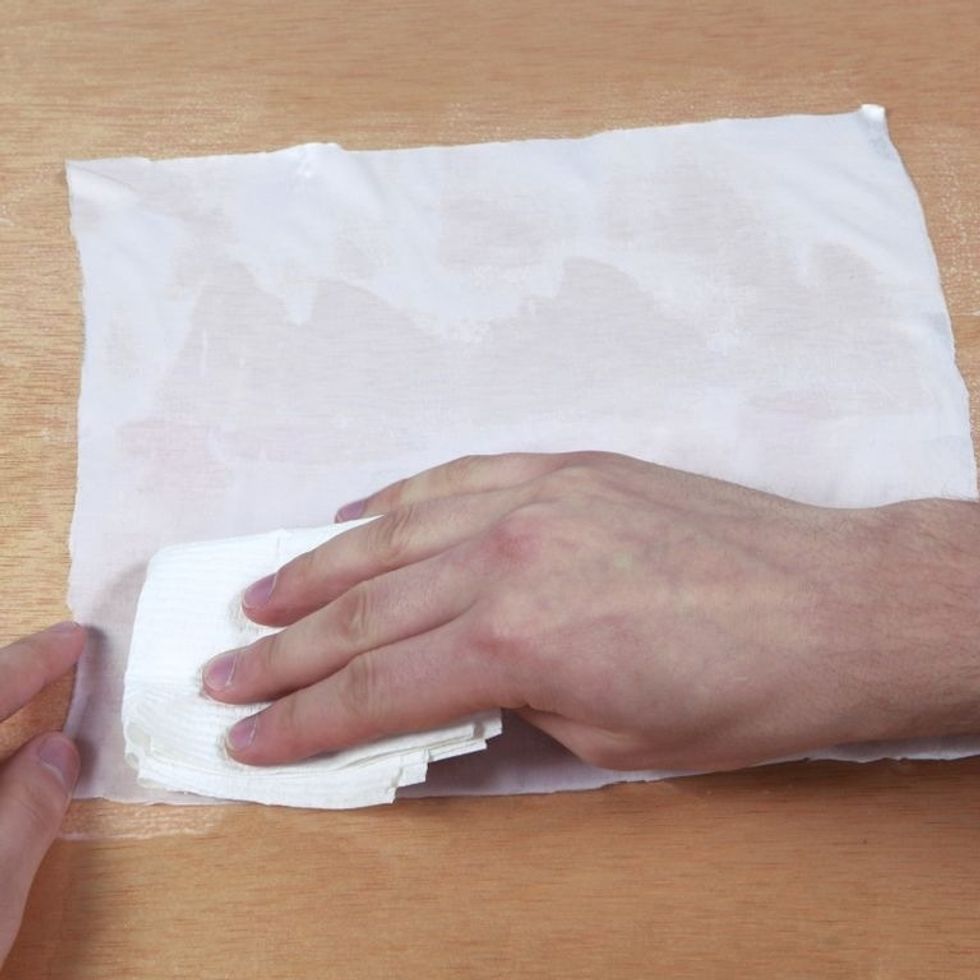 Using a paper towel, blot material to soak up excess dye. Tip: Less is more! Material should be fully coated but excess moisture can cause imperfections in prints. Material should be damp, not soaked.