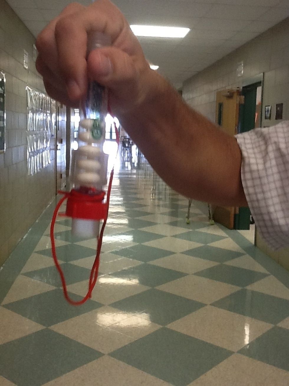 Using a paper towel, slide five Mint Mentos into the geyser tube horizontally. Try to touch them as little as possible