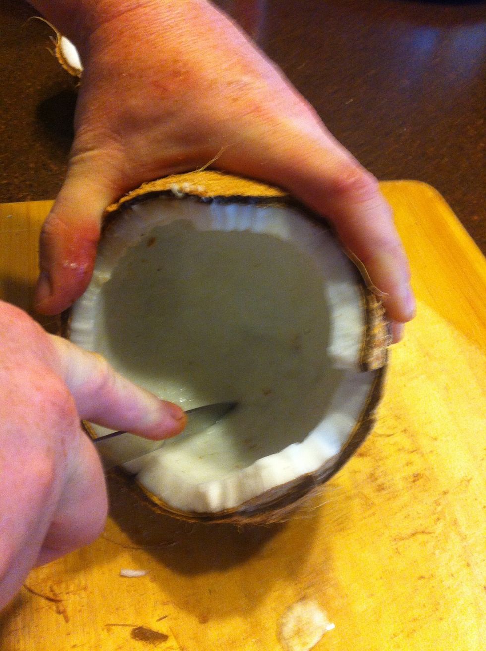 Using a paring knife, score the coconut flesh into wedges.