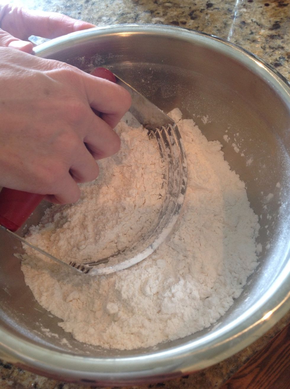 Using a pastry blender or two knives, blend together the butter and the dry ingredients. After a minute or two, you will have little pea sized pieces- this is a good thing.
