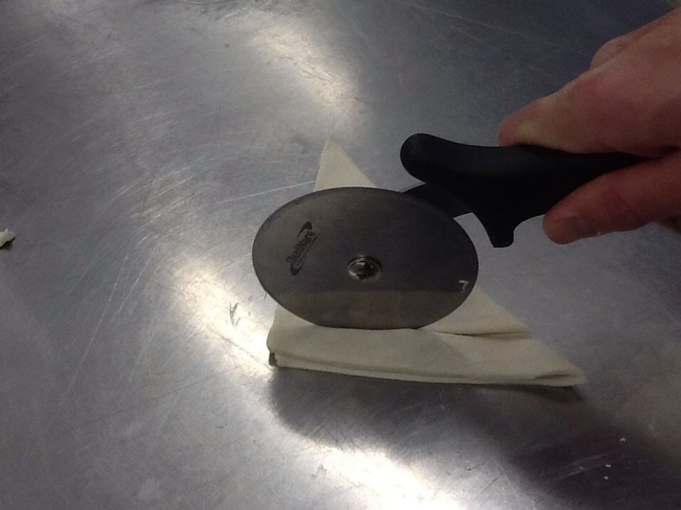 Using a pastry wheel or knife, cut from the long edge to the point. Leave a 5 millimetre gap at the end.