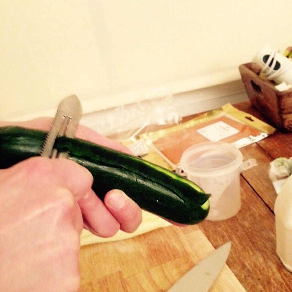 Using a peeler cut 3-4 lengthwise strips off the skin of one courgette