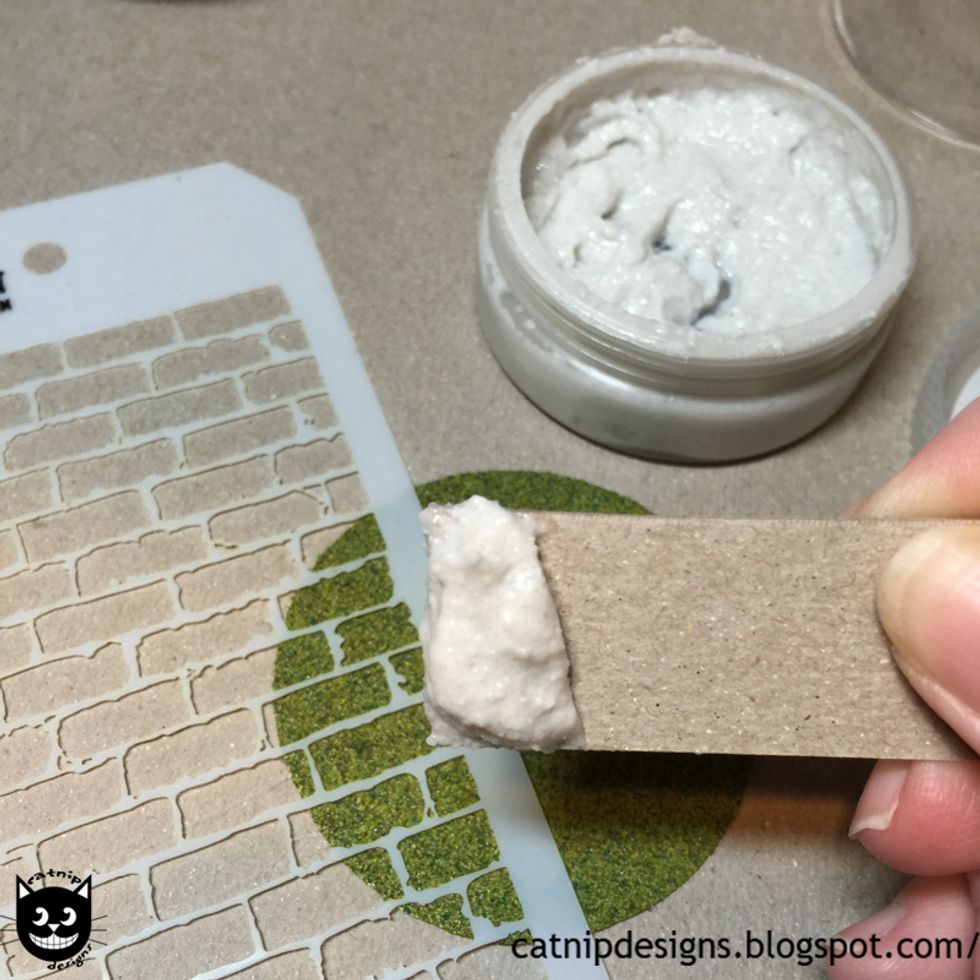 Using a piece of chipboard scoop up some Texture Paste.