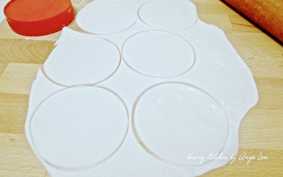 Using a round cutter, cut the thin dough into round shapes. This will ensure the dumpling wrappers are of the same size.