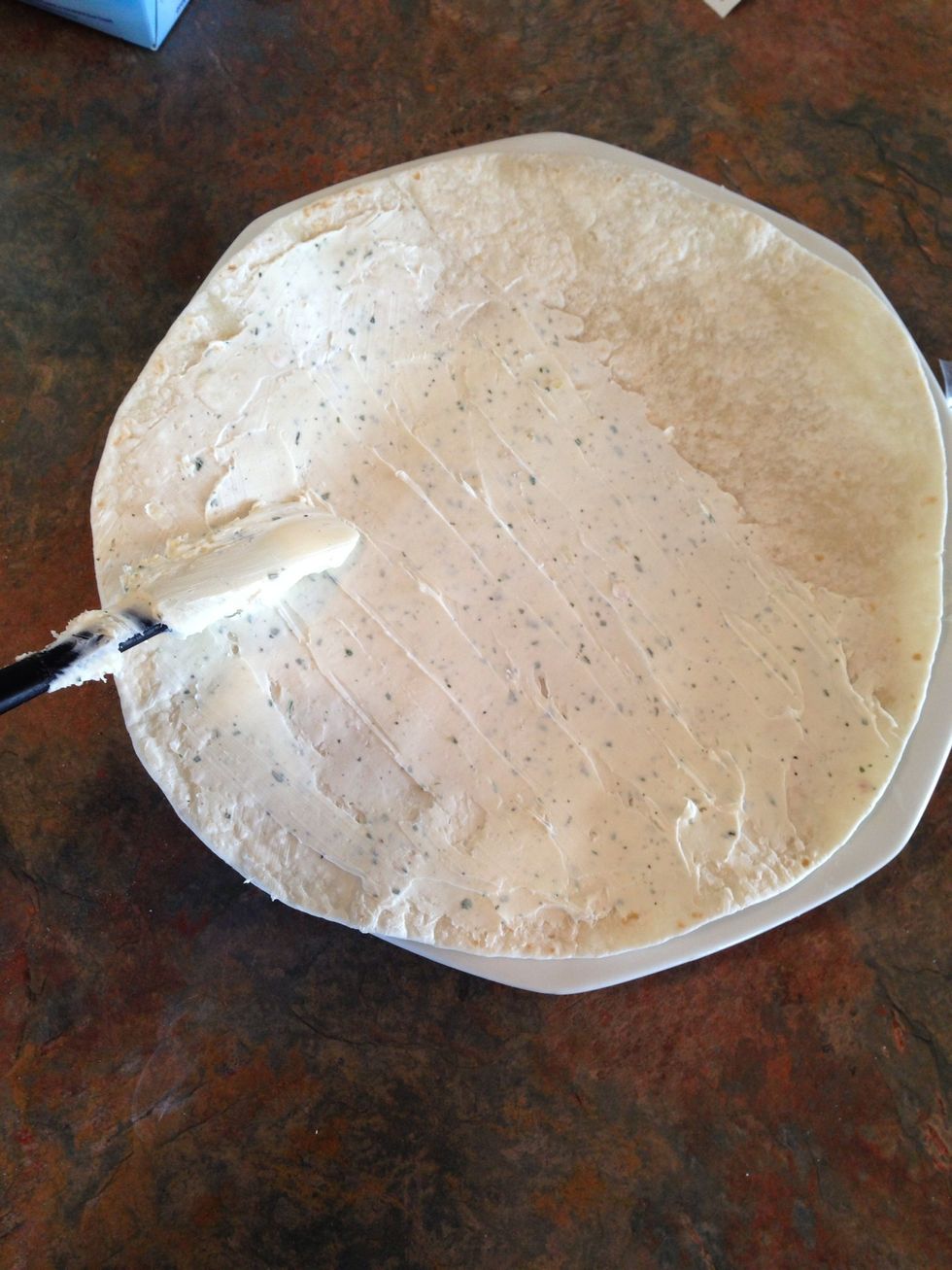 Using a rubber spatula, spread a thin layer of cream cheese/ranch mix on tortilla. **Only cover 3/4 of tortilla with mix.**
