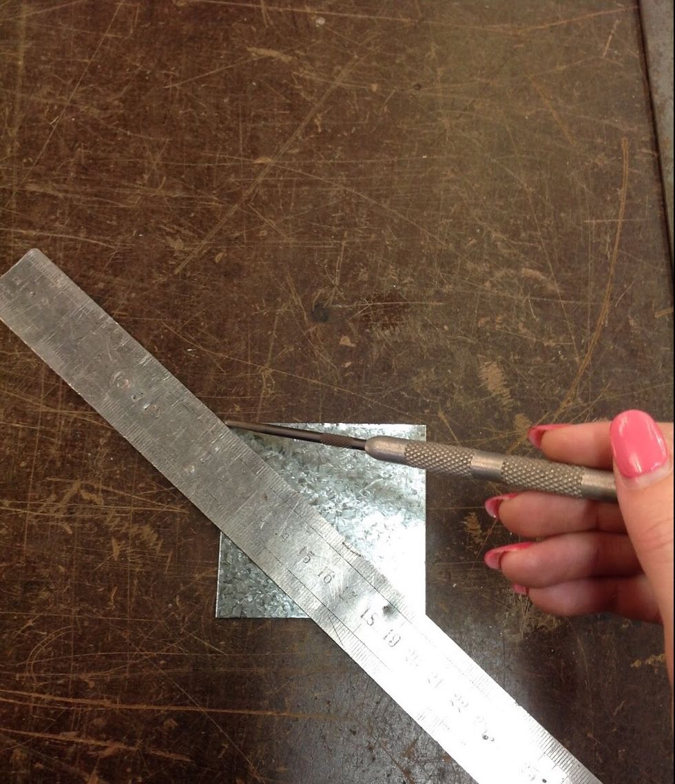 Using a ruler and scribe mark out a cross going from one corner to the other.
