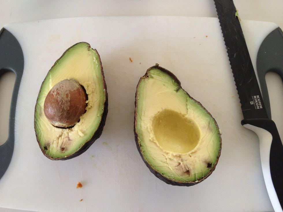 Using a sharp knife, slice avocado in half.