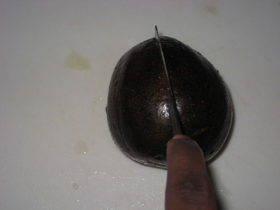 Using a sharp small knife, cut through the avocado into two halves.