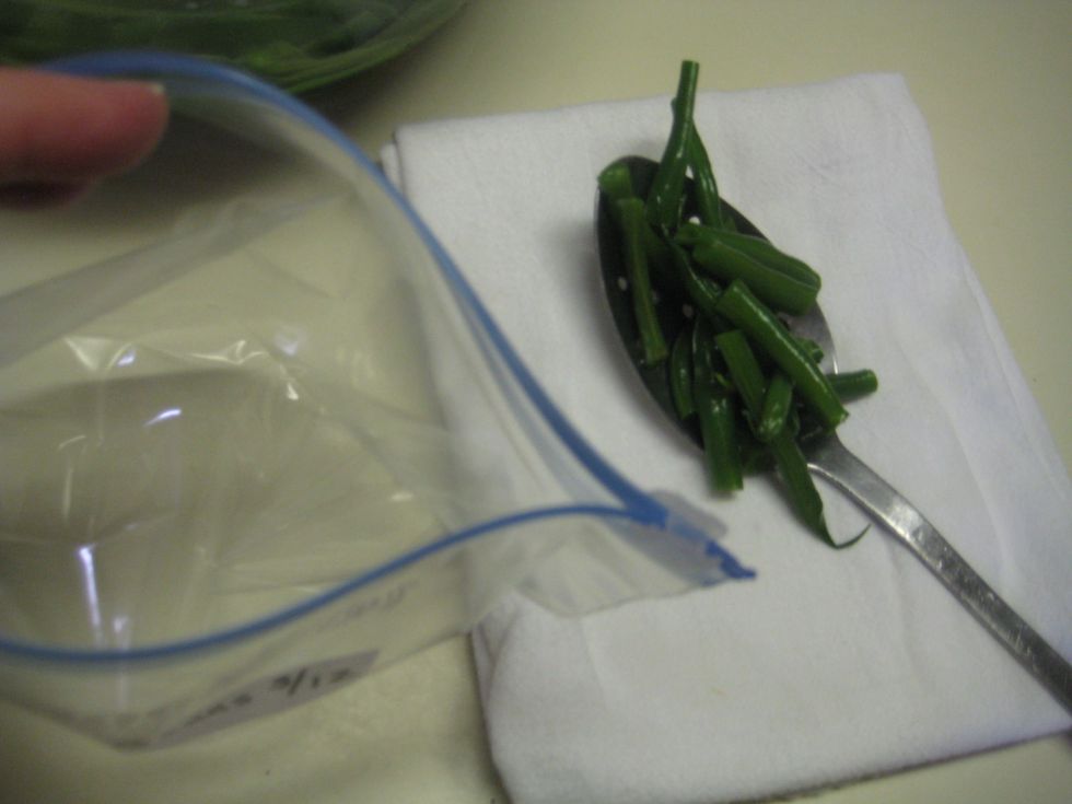 Using a slotted spoon, scoop and add blanched beans to the freezer bag , leaving an inch or so of space at the top to seal. Zip seal the bag.