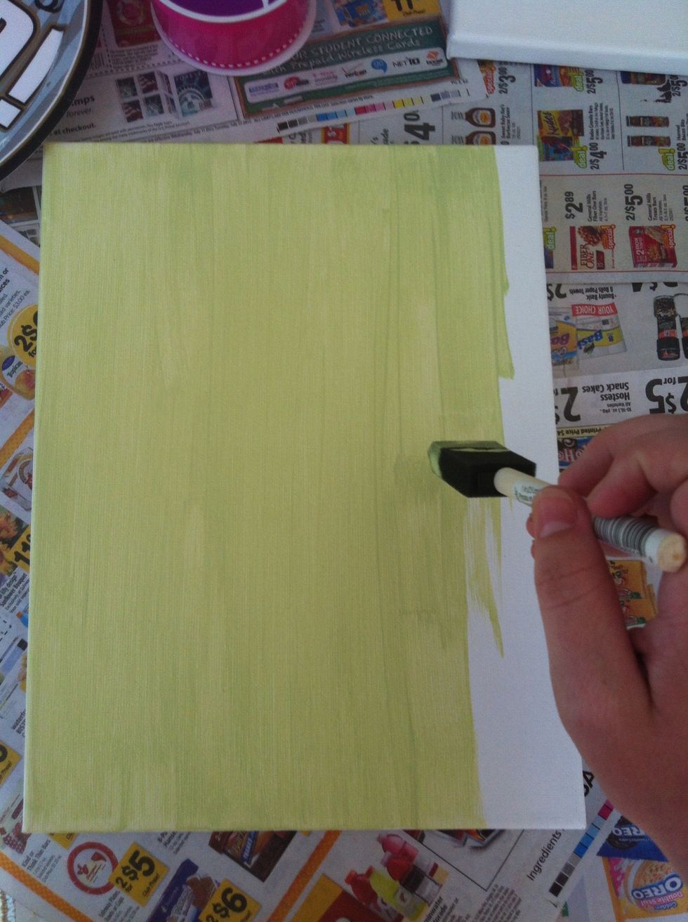 Using a small amount of acrylic paint from a paper plate, paint your canvas. Try to paint in one direction and make sure to paint the outer rims of the canvas as well.