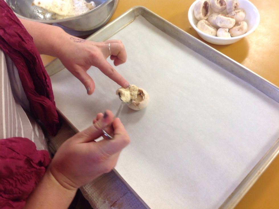 Using a spoon fill the mushroom caps with the filling. Smooth out the top of the filling and make it look visually appealing.