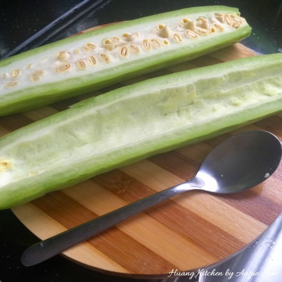 Using a spoon, scrape to remove all the seeds with membranes and pith, leaving only a thin layer of white flesh to the green skin of the bitter gourd.