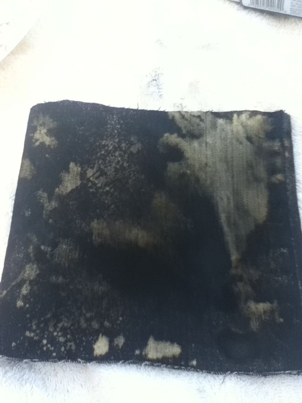 Using a spray bottle, spray some bleach on the jeans.