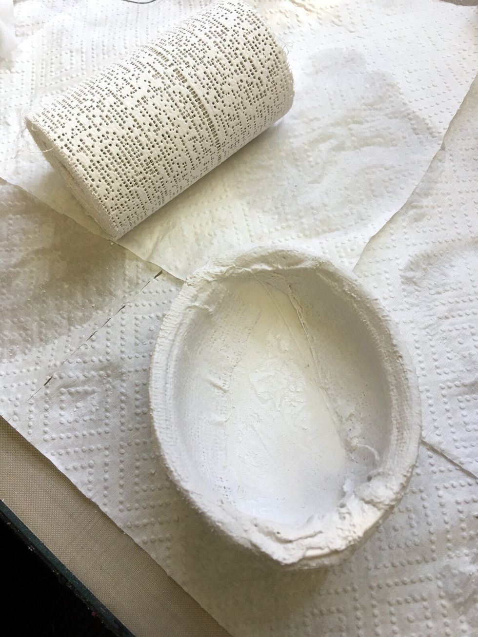 Using a strip of palster of paris approximately 5cm wide and 50cms long moisten in warm water and then apply to resin egg around inside edge, along rim, as depicted above.