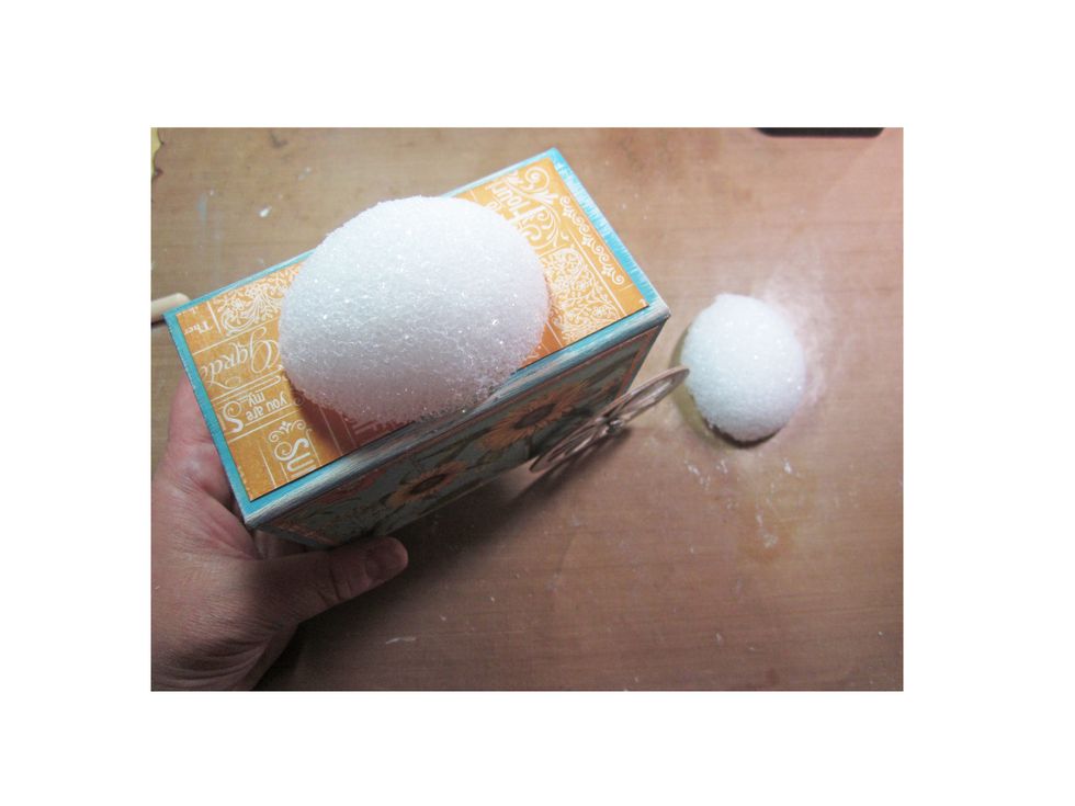 Using a styrofoam egg, cut in half and glue down to the top of the box.  Remember to cover your box with paper before you attach the egg.  This is going to be what holds our flowers.
