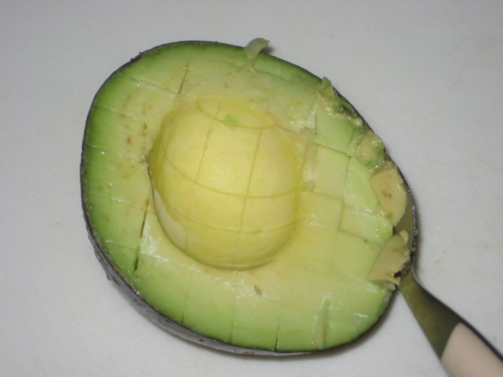 Using a suitable spoon, start scooping off the avocado and do it as close to the skin as possible to avoid wastes.