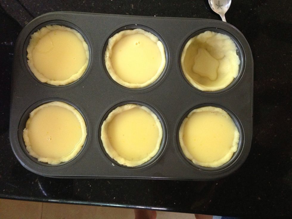 Using a tablespoon, carefully and slowly scoop runny custard mixture into each tart until just full, or slightly less. Place in oven, and bake for 15 - 25 minutes. Watch your tarts closely!