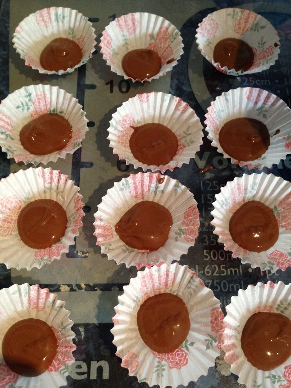 Using a teaspoon pour the chocolate into your mini cups ( there should be chocolate left over, you will need this later )