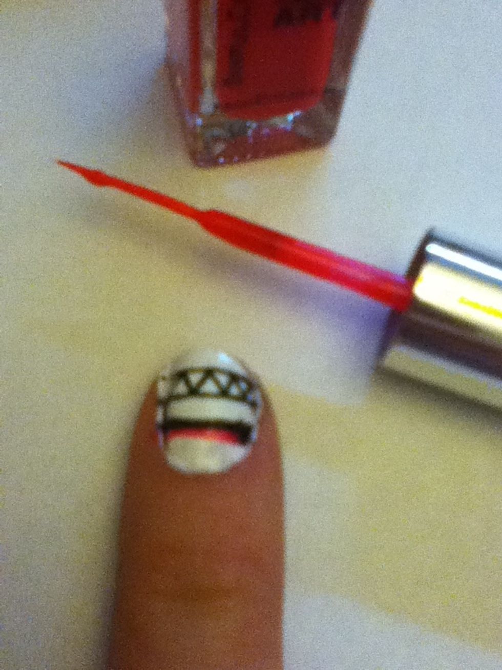 Using a thin brush, paint a line of pink nail polish under the black line.