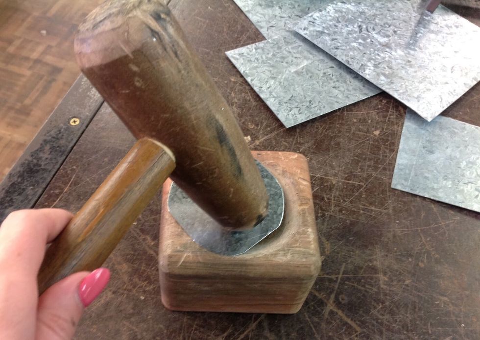 Using a tinmans mallet and a wooden mould, place your circle into the mould and begin to hammer the circle. Begin from the edges and then gradually make your way to the centre.