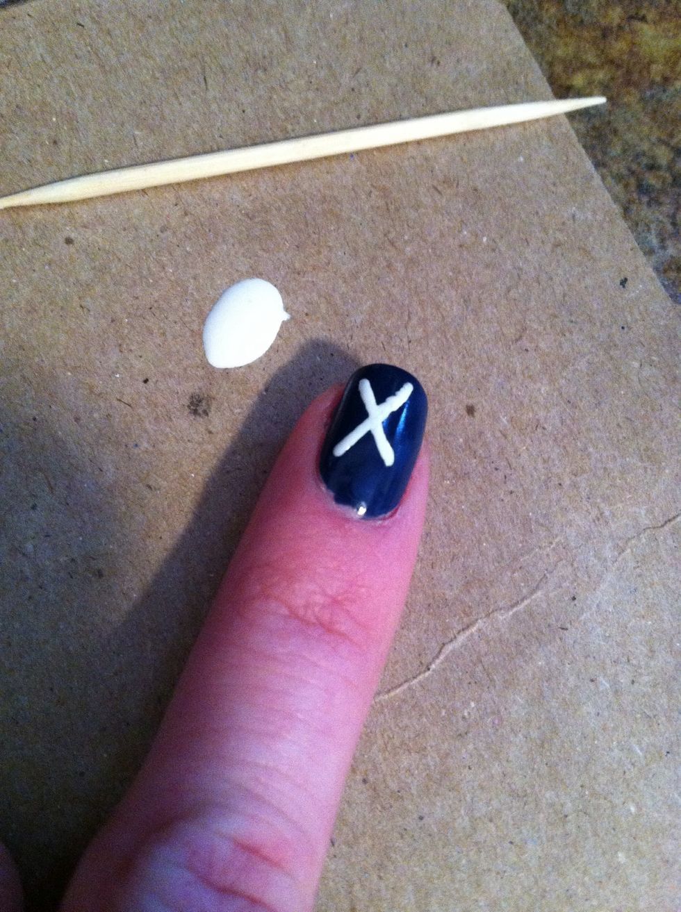 Using a toothpick, paint on a white X.