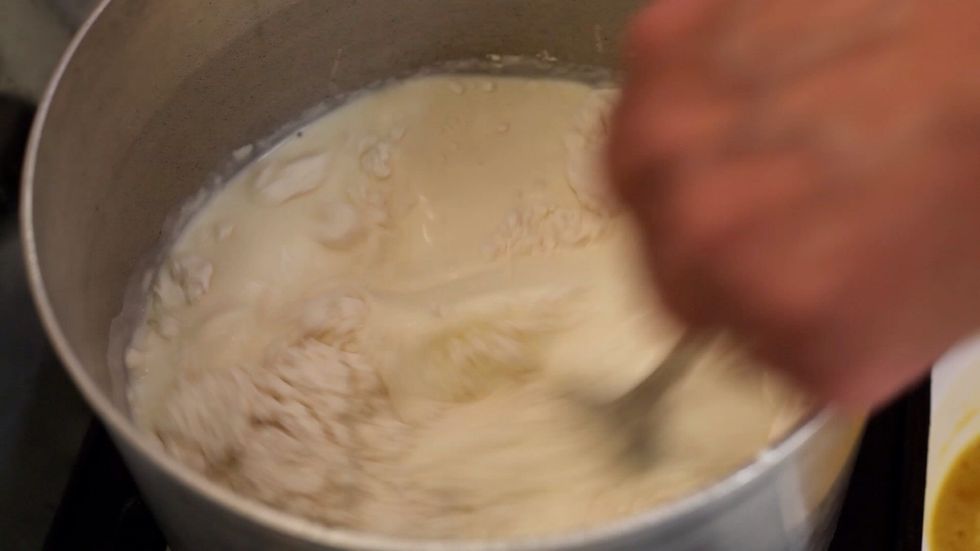 Using a whisk stir in your cornflour and all your ingredients while the milk is gently boiling on a medium heat. We used a terrible contraption which I'd never recommend. I'll show you in a sec.