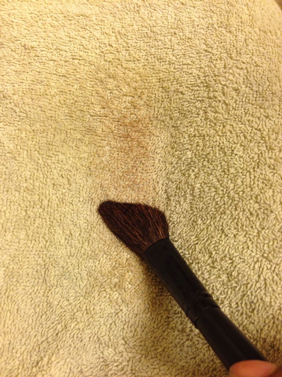 Using a wiping or circular motion, clean brushes onto towel.