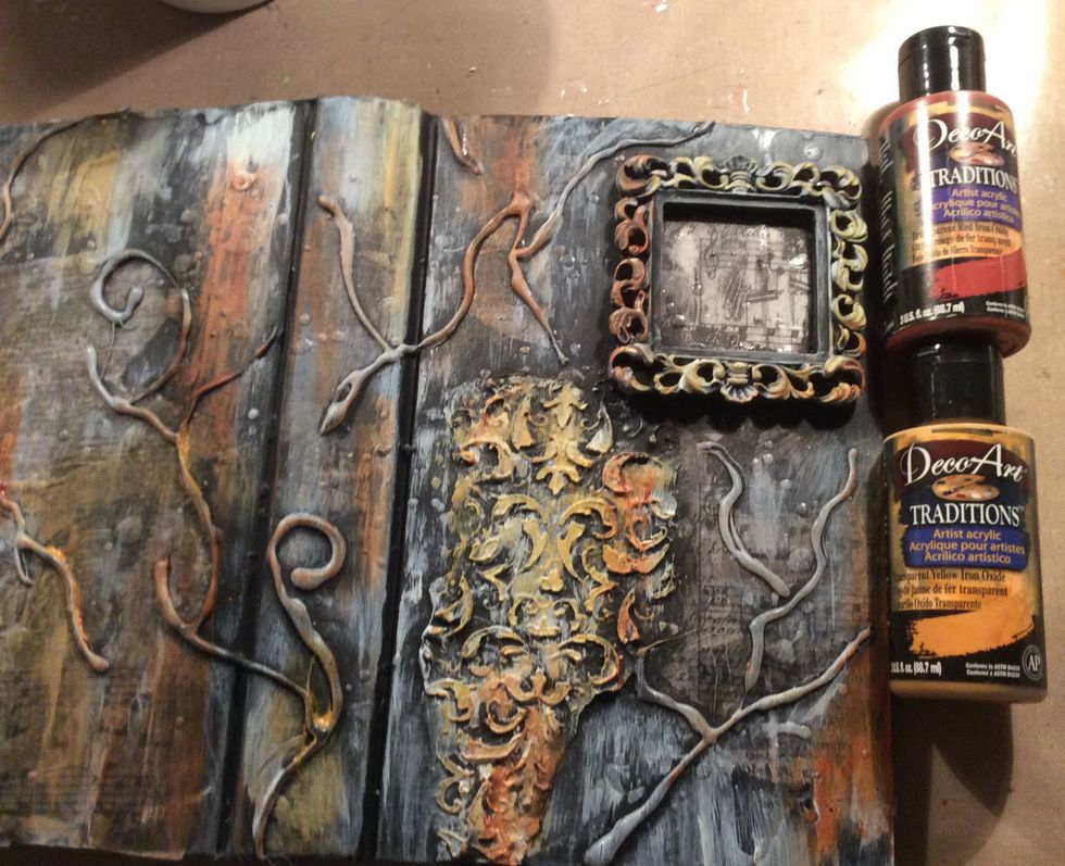 Using acrylics and my handy dandy finger I smeared paint here and there over the canvas and frame. Allow to dry.