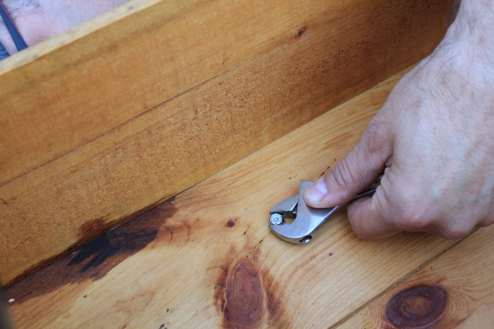 Using an appropriate size wrench to hold the nut in place, tighten each of the four bolts with a (philips) screwdriver a few turns at a time for each, rotating between the four bolts.