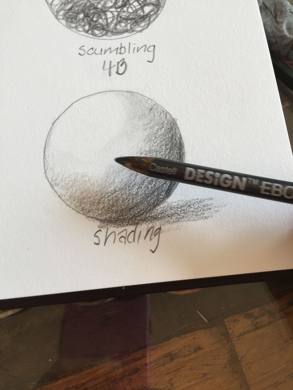 Using an ebony pencil try to shade the circle to appear like a ball. Darken areas away from the light source and gradually lighten as you near the light source