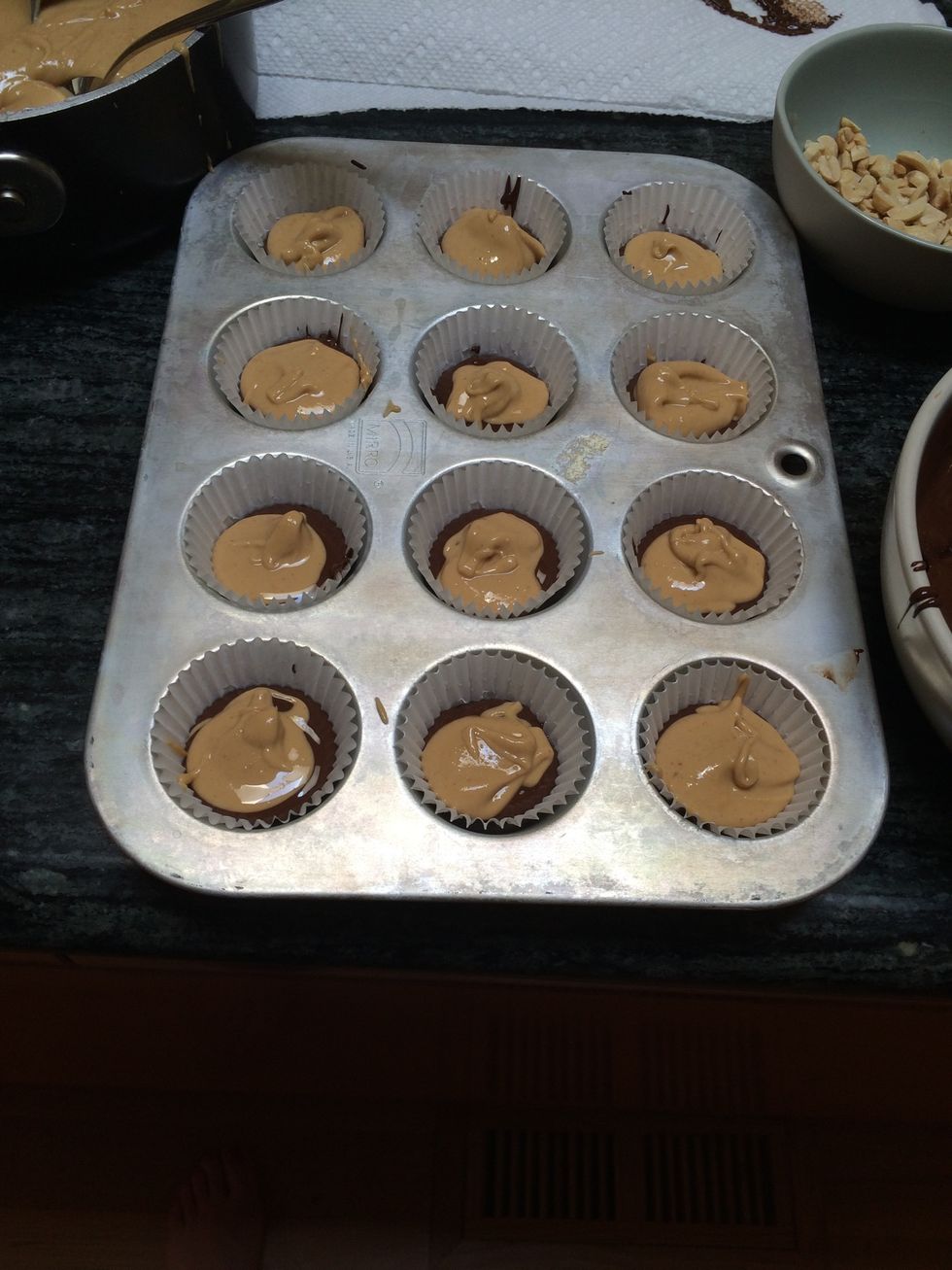 Using another spoon, place the center layer of peanut butter into the liners.