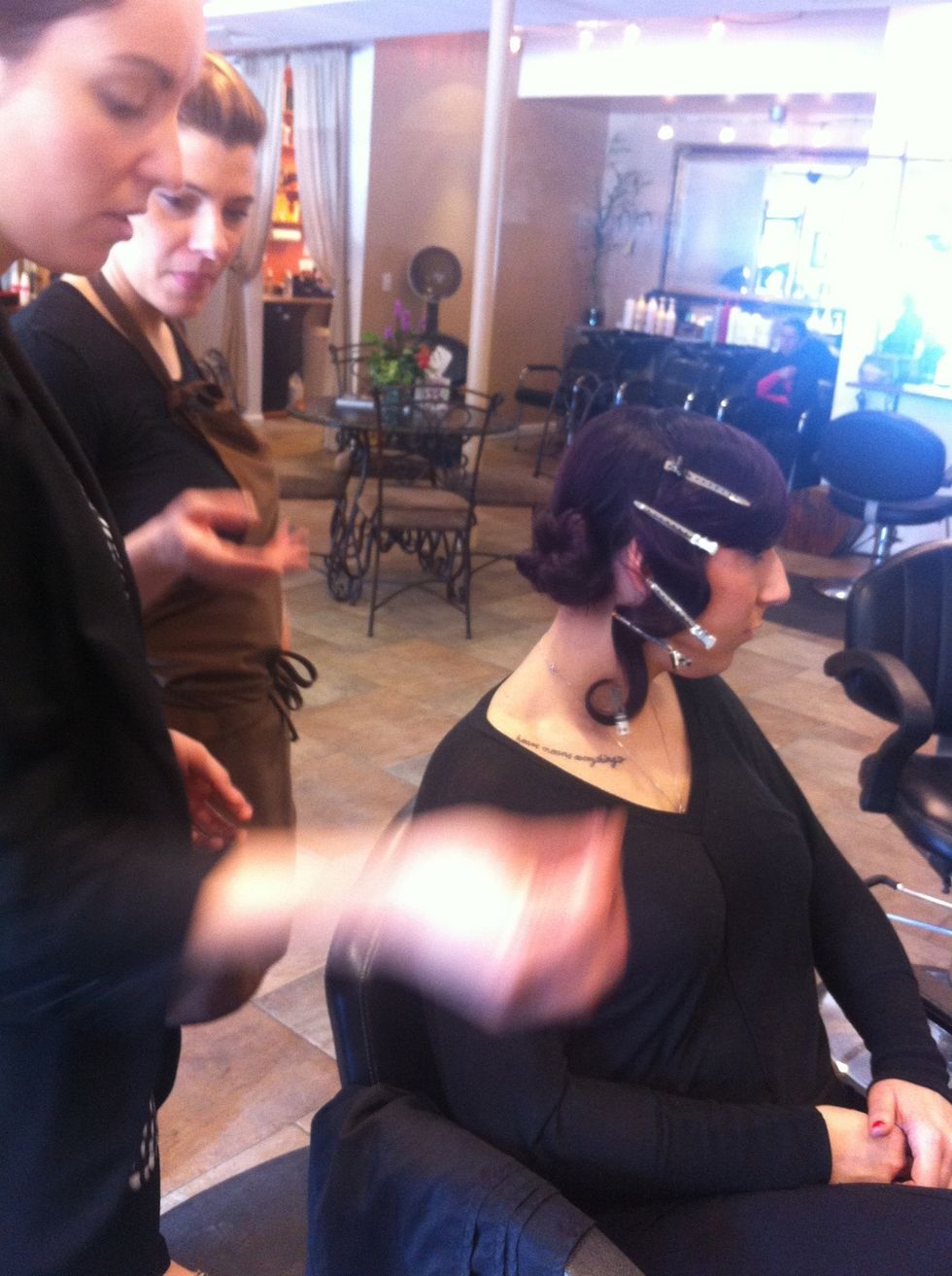 Using bobby pins to secure hair.. wrap hair in a circular motion to create a bun like shape