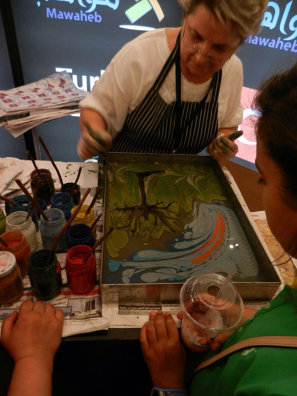 Using brown paint, she created a tree, using the brush to draw the paint into shapes.