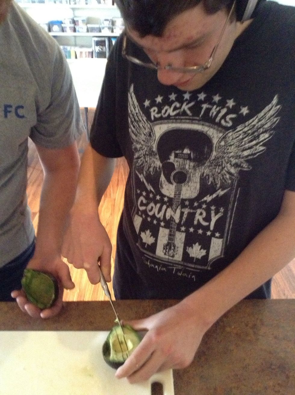 Using butter knife cut lines into the flesh of the avocado
