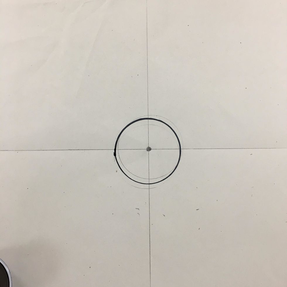 Using  cup, make the 1st circle in the center. Be sure the dot is in the center of circle as best as you can. Use pencil first then marker.